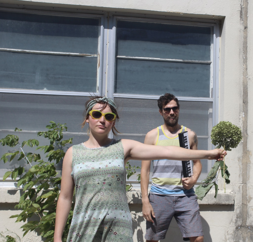 David and Bree posing in an alley with keyboard and flower